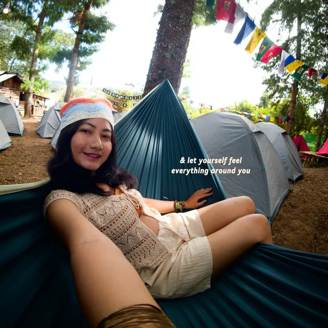 A traveller relaxing in a hammock at camp